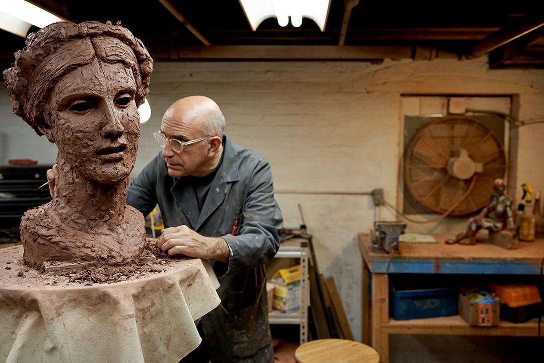 George Petrides modeling a portrait head in clay